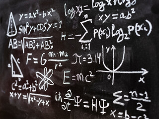 Operaciones y formulas de física cuántica y matemáticas escritas a mano con una tiza en la...