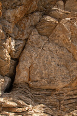 Sandstone rock or stone wall background with weathered cracks and old worn texture in red orange...