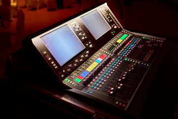 Closeup image of a hand mixing sounds on a control board, showcasing an audio technicians work