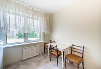 Minimalist Kitchen Interior with Table and Chairs by Bright Window