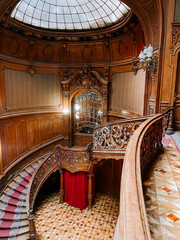 Intricate wooden staircase in an elegant historical building with ornate details