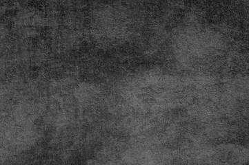 A detailed close-up reveals a weathered, dark gray textured background with subtle variations.