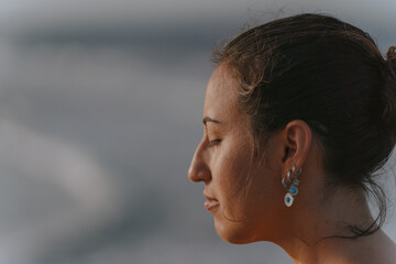 Woman meditating with closed eyes, enjoying peace and serenity by the sea