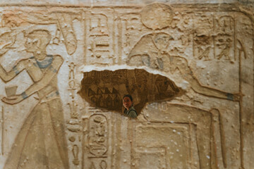 Tourist exploring ancient egyptian temple wall carvings