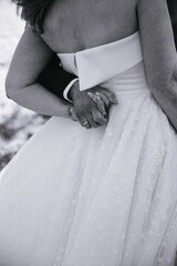 Back view of a bride holding hands with the groom