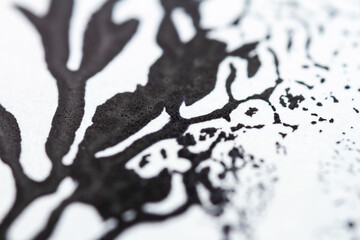 Extreme close up of black acrylic paint texture on paper. Selective focus.