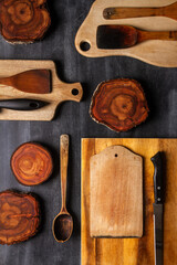 Wood log tree slices and cutting boards on black chalkboard. Flat lay. Top view