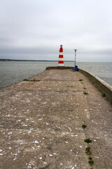 Lighthouse on a concrete pier under a cloudy sky in Nida, Curonian Spit and Curonian Lagoon, Lithuania