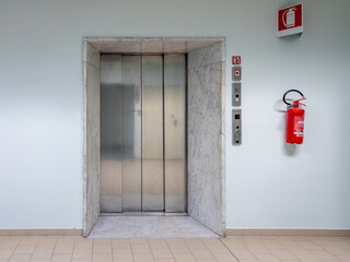 Litter stretcher elevator to hospital floor with red fire extinguisher on the wall © framarzo