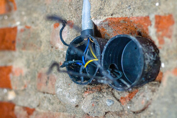 Dismantle and repair electrical outlets on brick walls.