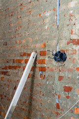 Dismantle and repair electrical outlets on brick walls.