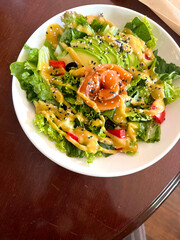 Fresh salmon and avocado salad in white bowl. Balanced ingredients, healthy meal, top-down view, clean food concept.