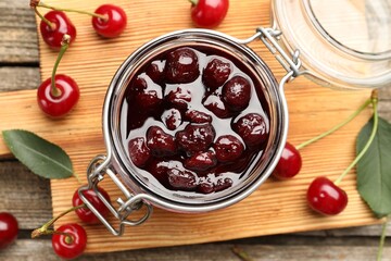 Tasty cherry jam and fresh fruits on wooden table, flat lay