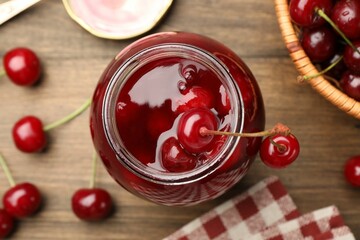 Tasty cherry jam and fresh fruits on wooden table, flat lay