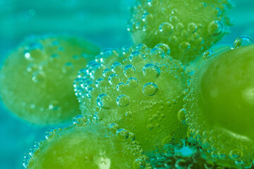 Fresh green grapes submerged in clear water create an appealing view as bubbles