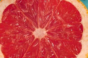Freshly sliced grapefruit revealing vibrant segments and juicy texture on a colorful background