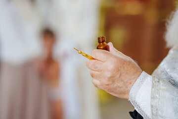 The priest performs chrismation at the sacrament of baptism.