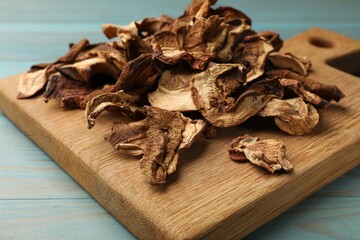 Dried chanterelle mushrooms on blue wooden table, closeup