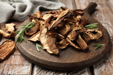 Dried chanterelle mushrooms with rosemary on wooden table, closeup