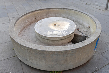 Naklejka premium Empty Round Concrete Water Fountain at City Square Winter Day
