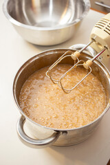 Elderly Woman Mixing Dough with a Hand Mixer