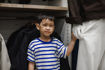 Little boy holding mannequin hand in clothing store