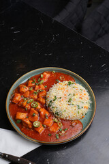 Top view of Chicken manchurian with some fried rice on the dark background