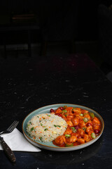 Szechuan Chicken with some fried rice on the dark background