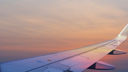 commercial airplane flying above over sky in sunset light.