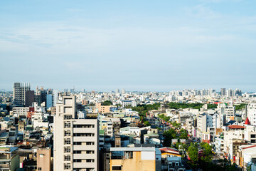 Tainan, Taiwan – Jun 30, 2025: Aerial view of Tainan City under a bright blue sky. Residential blocks, streets, and high-rise apartments create a dense urban skyline in southern Taiwan.

