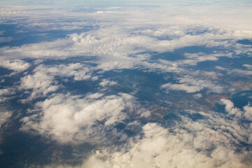 beautiful thick clouds in the sky from the height of the flight of the plane with a view of the continent and countries