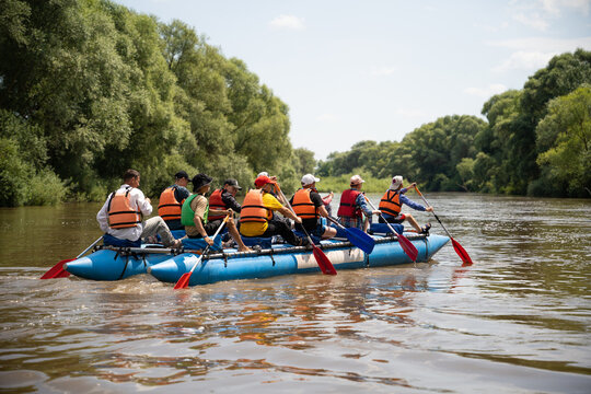 a team of athletes on a catamaran overcomes obstacles floating on the river