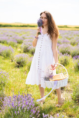 beautiful girl in a dress on a lavender field with a bouquet of flowers