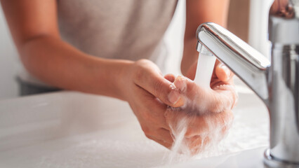 Woman washing her hands in the bathroom
