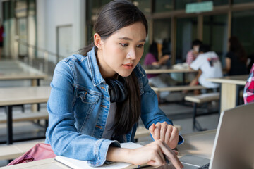 Beautiful Asian woman female student excited checking language test results on laptop. Smile girl...