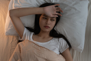 woman in bed late trying to sleep suffering insomnia, sleepless or scared in a nightmare, looking...