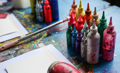 Closeup dirty plastic bottles contain water color in the wooden tray. artistic concept