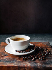 Coffee cup and coffee beans on gray background,  Espresso coffee cup aromatic on a wooden tray