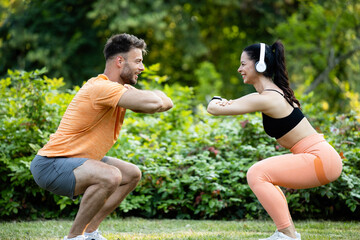 Fitness people exercising and doing squats together in the park.