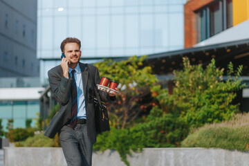 Stressed office worker shouting on phone while juggling coffee cups