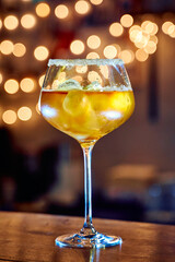 Elegant sparkling wine glass with ice and sugared rim against warm bokeh