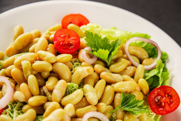 Bean salad green leaf lettuce, tomato, onion vegetables dish fresh delicious gourmet food background on the table rustic food top view copy space keto and paleo diet vegan and vegetarian food