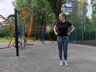 girl doing sports on the outdoor playground. young woman doing exercises