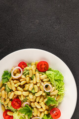 Bean salad green leaf lettuce, tomato, onion vegetables dish fresh delicious gourmet food background on the table rustic food top view copy space keto and paleo diet vegan and vegetarian food