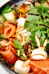 Fresh arugula salmon salad with pine nuts and mozzarella