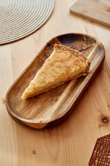 Delicious slice of homemade apple pie on wooden plate in rustic kitchen setting