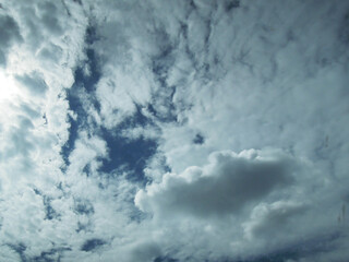 A dramatic sky filled with dense grey clouds interspersed with bright sunlight breaking through...