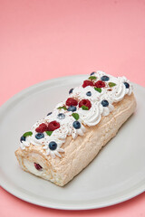 Delightful pavlova roll with fresh berries and creamy whipped topping on plate