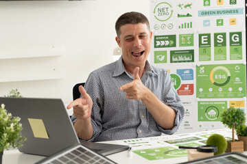 A diverse business team analyzing environmental charts and graphs in a collaborative meeting to create sustainable strategies in a modern office.