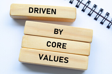 Driven by core values text on wooden blocks and notebook represents purposeful direction guided by foundational beliefs